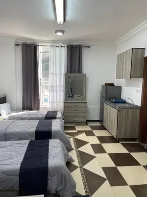 a bedroom with two beds and a checkered floor at Al safa in Amman