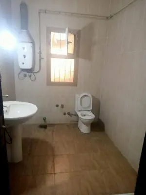 a bathroom with a toilet and a sink and a window at صبحه هاوس in Şabḩā