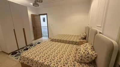 a bedroom with two beds and a door to a hallway at صبحه هاوس in Şabḩā