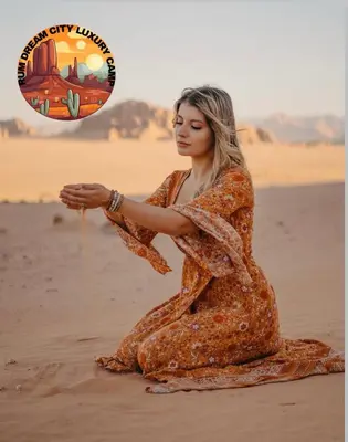 a woman sitting on the sand in the desert at RUM DREAM CITY lUXURY CAMP in Wadi Rum