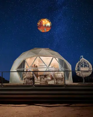 a kite flying over a domed building at night at RUM DREAM CITY lUXURY CAMP in Wadi Rum