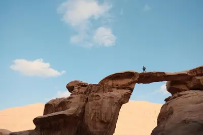 a person standing on top of a rock in the desert at Wadi Rum Desert Experience in Wadi Rum