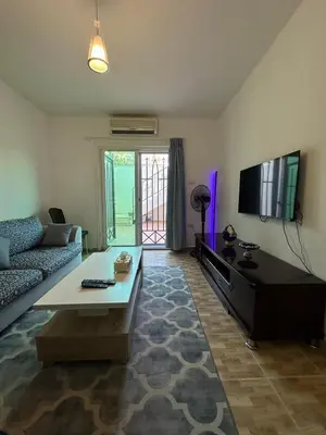 a living room with a couch and a flat screen tv at MK4 - One Bedroom Apartment in Amman