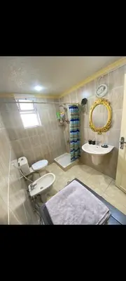 a bathroom with a sink and a toilet and a mirror at Central Jabal Alweibdeh in Amman