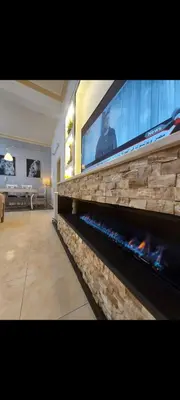 a living room with a fireplace with a flat screen tv at Central Jabal Alweibdeh in Amman