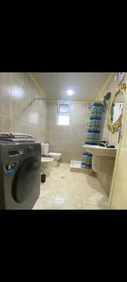 a bathroom with a washing machine and a sink at Central Jabal Alweibdeh in Amman