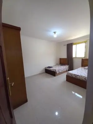 an empty room with two beds and a door at المزار لوج in Al Mazār