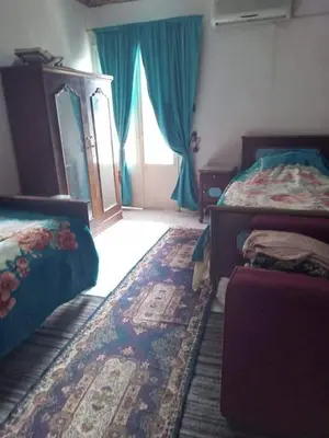 a bedroom with two beds and a mirror and a window at المزار لوج in Al Mazār