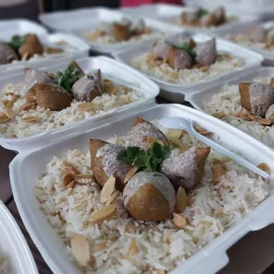 a group of trays of food on top of rice at المزار لوج in Al Mazār