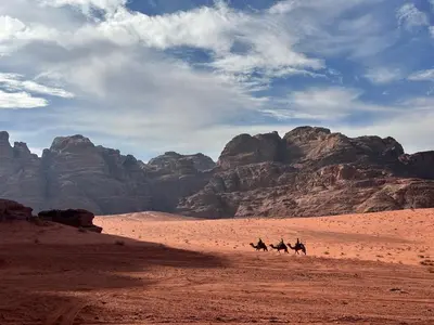 a group of people riding horses in the desert at Wadi Rum Cave Experience in Wadi Rum