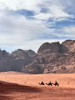 a group of people riding horses in the desert at Wadi Rum Cave Experience in Wadi Rum
