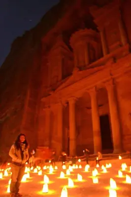 a woman standing in front of a building with candles at man -soor in Amman