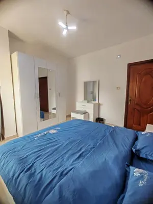 a bedroom with a large blue bed in it at Khalda One Bedroom Apt in Amman