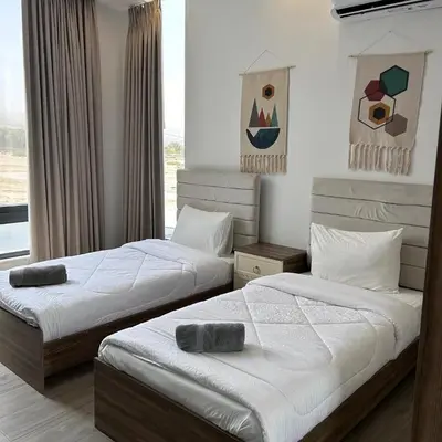 a bedroom with two beds and a window at Bow Villa in Sowayma
