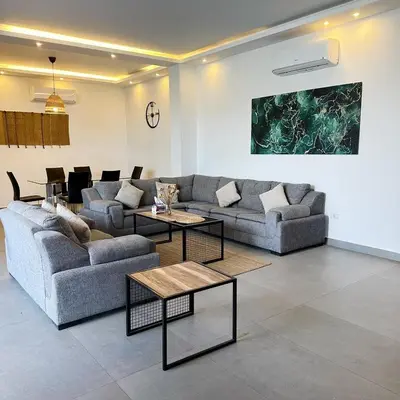 a living room with two couches and two tables at Bow Villa in Sowayma
