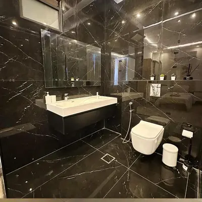 a black bathroom with a sink and a toilet at Bow Villa in Sowayma