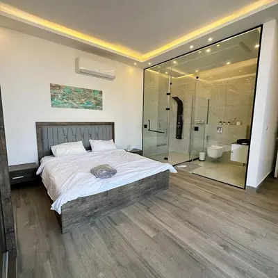 a bedroom with a large bed and a shower at Bow Villa in Sowayma