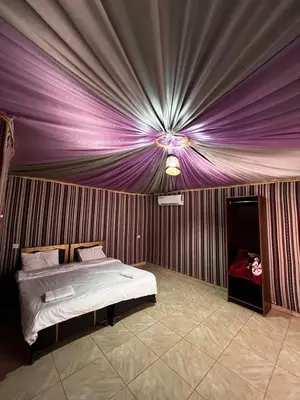a bedroom with a bed with a purple ceiling at Wadi rum camp hamod in Wadi Rum