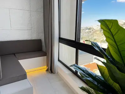 a room with a window with a bench and a plant at Central Amman Stunning Views Apt in Amman