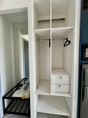 a closet with white shelves and a bed in a room at Central Amman Stunning Views Apt in Amman