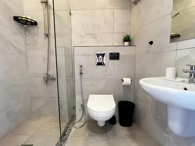 a bathroom with a shower and a toilet and a sink at Modern Studio Apartment Near Downtown, breathtaking view! in Amman