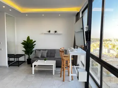 a living room with a couch and a table at Modern Studio Apartment Near Downtown, breathtaking view! in Amman