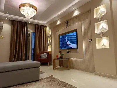 a living room with a couch and a tv on a wall at بليله هاوس in Balīlā