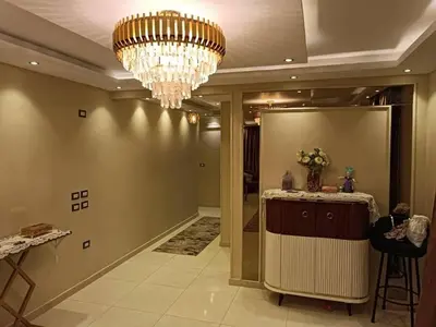 a room with a chandelier and a hallway with a counter at بليله هاوس in Balīlā