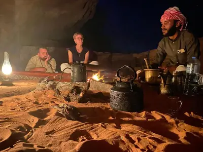a group of people sitting around a camp fire at Wadi Rum Starlit in Wadi Rum