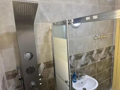 a bathroom with a shower and a sink at Al-Amer شقق الخامسه الراقيه in Aqaba