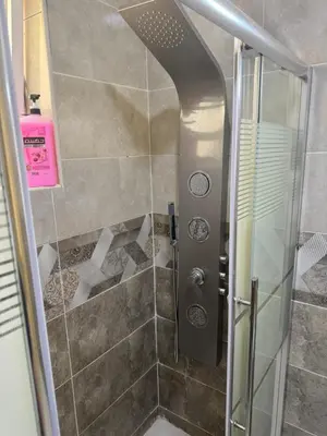 a shower with a glass door in a bathroom at Al-Amer شقق الخامسه الراقيه in Aqaba