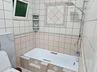 a bathroom with a tub and a toilet at شقة 3غرف نوم في ضاحية الرشيد in Amman