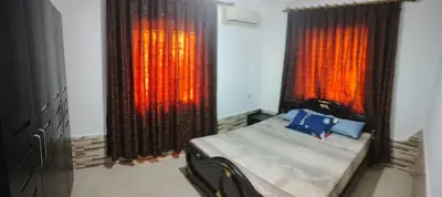 a bedroom with a bed and two large windows at Apartments for Rent in Irbid