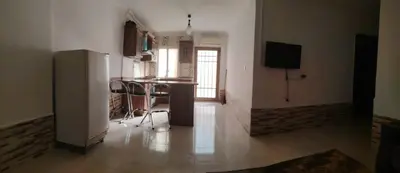 a kitchen with a refrigerator and a table in a room at Apartments for Rent in Irbid