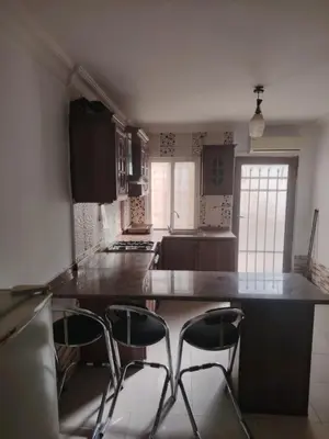a kitchen with a counter and two stools in it at Apartments for Rent in Irbid