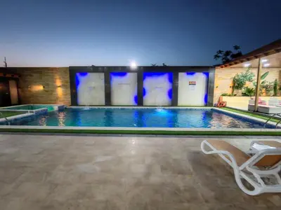 a swimming pool at night with a white chair next to it at Wonder Villa in Al Rama