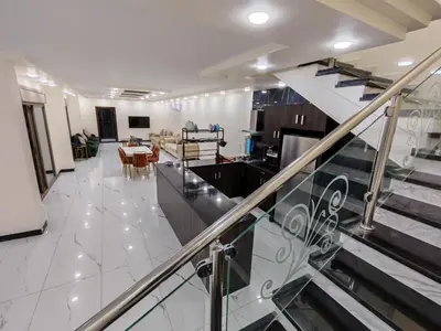 a living room with a staircase and a dining room at Wonder Villa in Al Rama