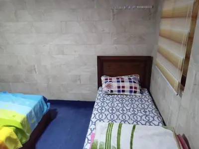 a room with two beds and a brick wall at Sky2 in Jerash