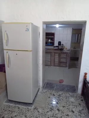 a kitchen with a white refrigerator in a room at Sky2 in Jerash