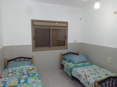 two beds in a room with a window at Sky 2 in Jerash