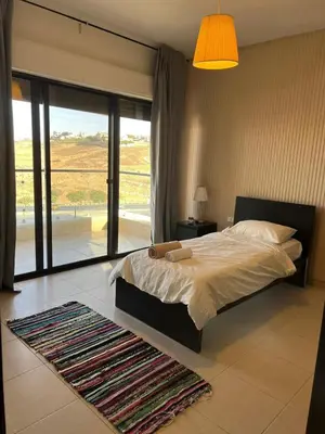 a bedroom with a bed and a large window at Abdoun is comfortable accommodation and an exceptional location close to the mall in Amman