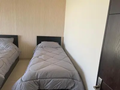 a bedroom with two beds in the corner at Abdoun is comfortable accommodation and an exceptional location close to the mall in Amman