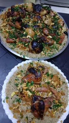 two plates of food with meat and rice on a table at ranos villa in An Nu‘ayyimah