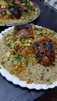 a plate of rice with chicken and other food at ranos villa in An Nu‘ayyimah