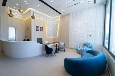 a lobby with a large white table and blue chairs at Hill Top Hotel in Aqaba