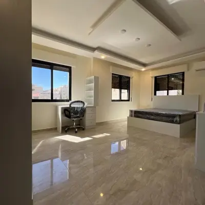 a bedroom with a bed and a desk and a chair at اربد in Irbid