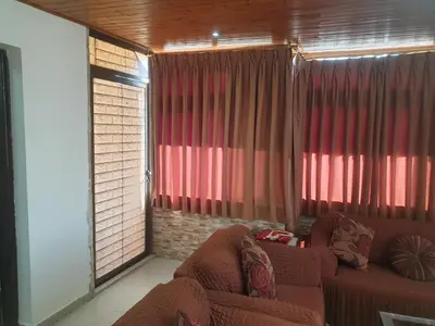 a living room with red curtains and a couch at الاردن عمان تلاع العلي شارع ابو يوسف الأنصاري اسكان طارق الشيخ in Amman