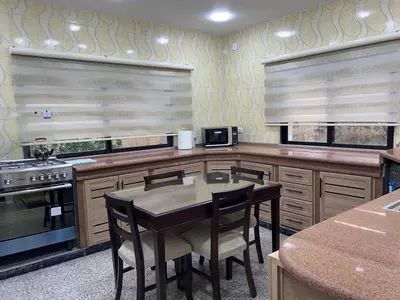 a kitchen with a table and some chairs and a stove at Raha's house in Jerash