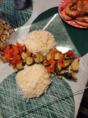 a plate of rice and vegetables on a table at النعيمه هاوس in An Nu‘ayyimah