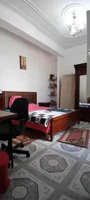 a bedroom with a bed and a desk and a chair at النعيمه هاوس in An Nu‘ayyimah